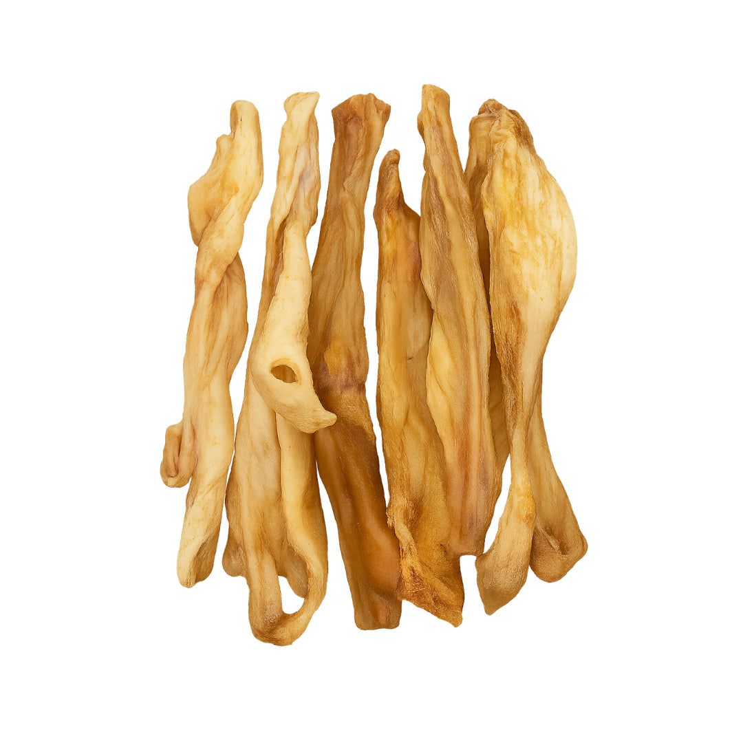 Verschillende gedroogde stukken geitenkop, lichtbruin, onregelmatige vorm, op witte achtergrond.