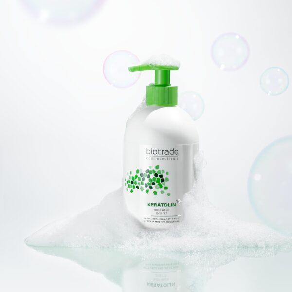 Flacon blanc avec pompe verte, entouré de mousse et bulles. Inscription Biotrade et Keratolin.