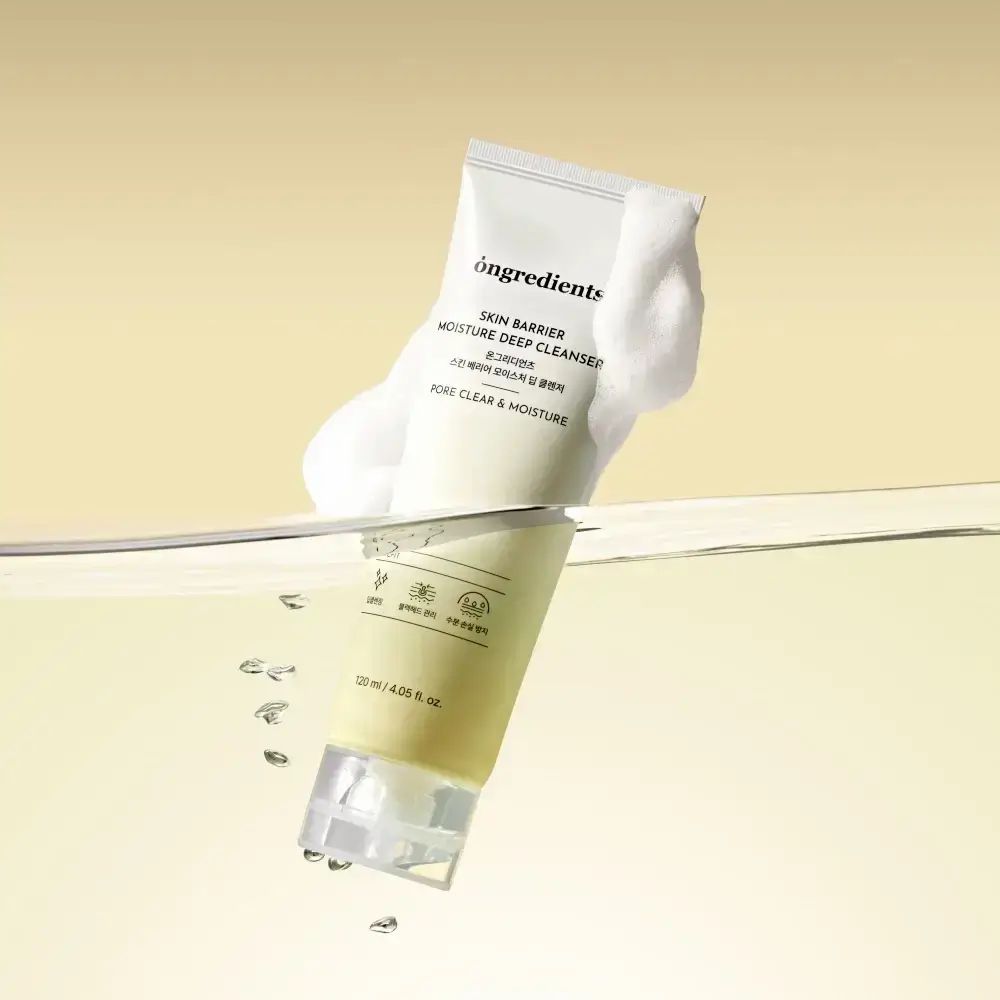 Crèmekleurige tube in water. Schuim rond de tube. Opschrift: Skin Barrier Moisture Deep Cleanser. 120 ml.