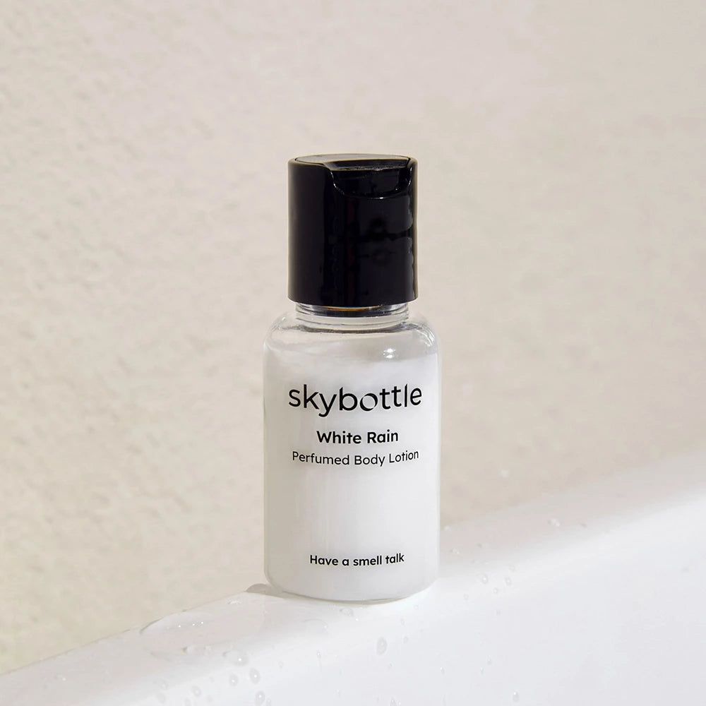 Flacon de lotion pour le corps, blanc, bouchon noir. Inscription : SKYBOTTLE White Rain Parfümierte Körperlotion.