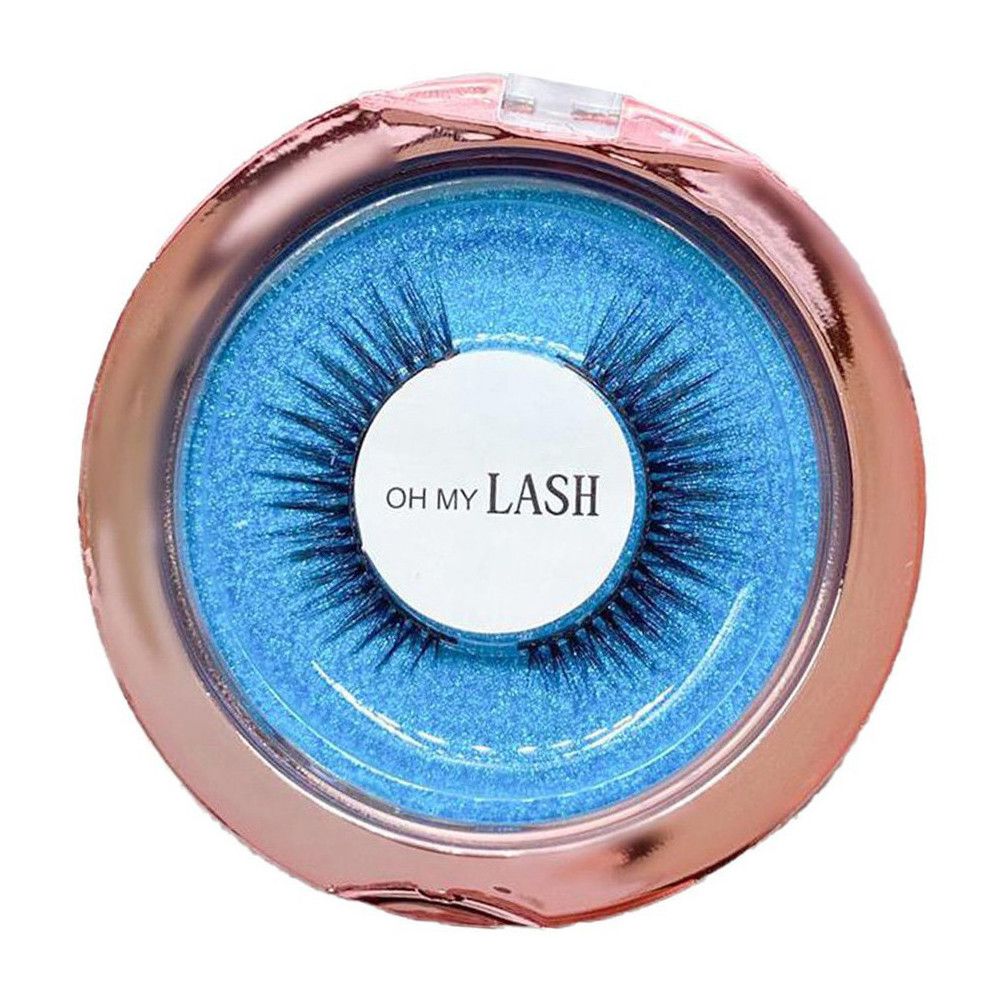 Boîte ronde dorée rose avec couvercle transparent ouvert. Intérieur bleu avec faux cils. Étiquette blanche avec "OH MY LASH".