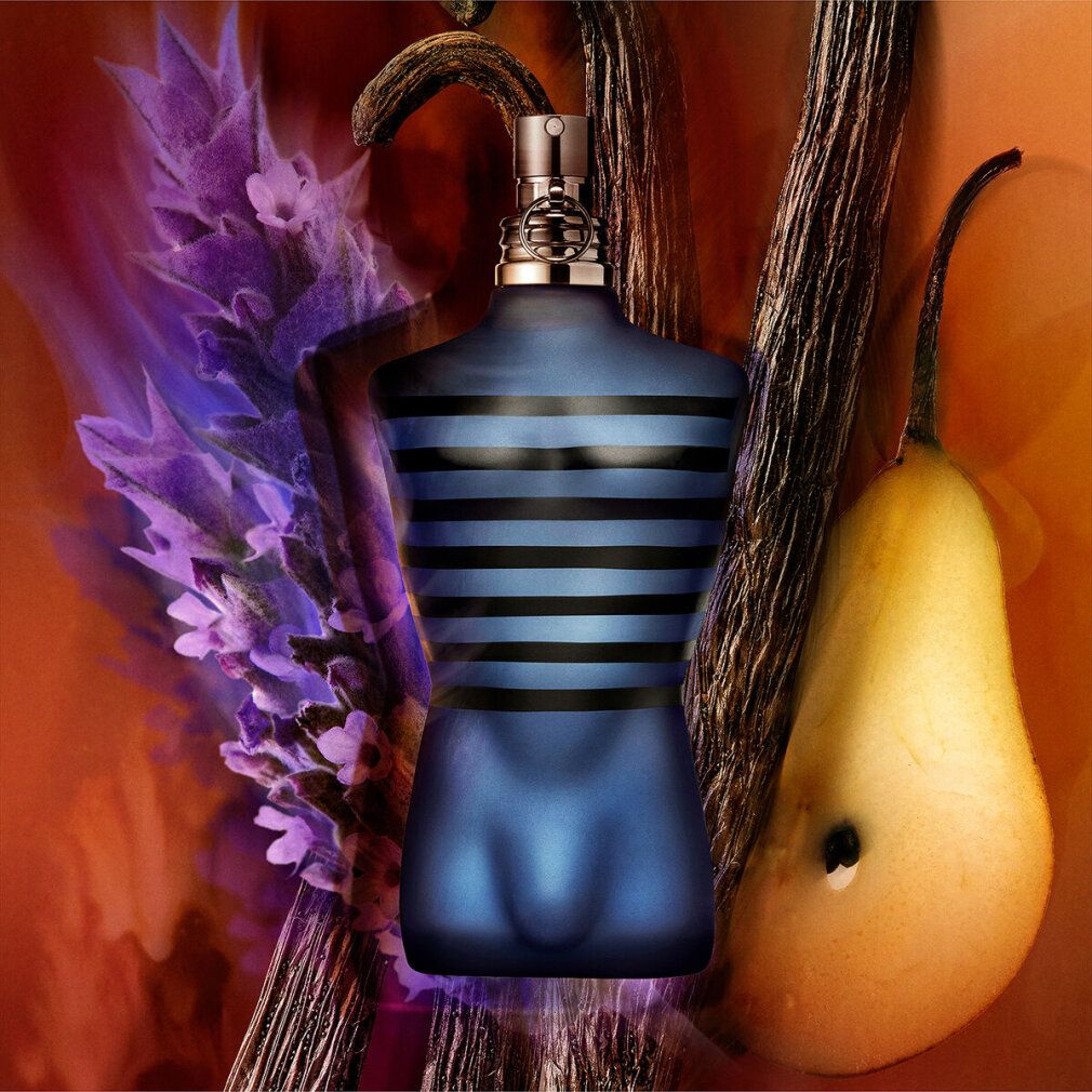 Blauwe torso-vormige fles, omringd door lavendel, peer en specerijstokken. Oranje achtergrond.