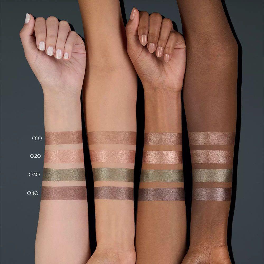 Quatre bras avec différents tons de peau. Quatre couleurs d'ombres à paupières sont appliquées sur chaque bras. Couleurs : marron, vert, or.