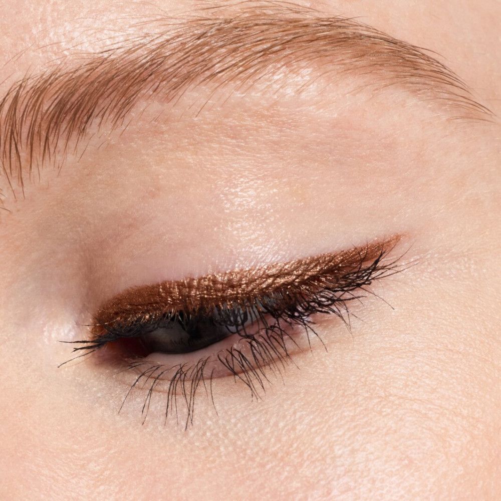 Gros plan d'un œil avec crayon pour les yeux appliqué. Couleur marron.
