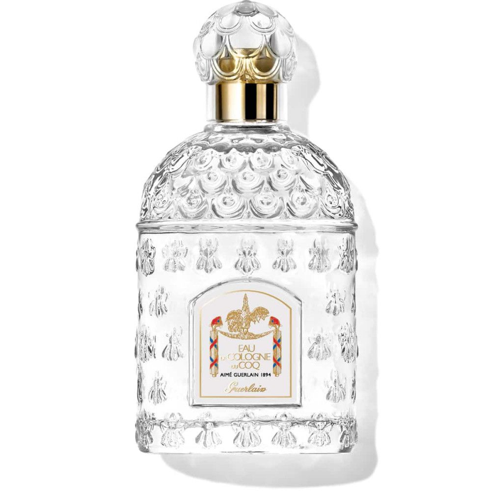 Flacon transparent avec bouchon doré. Étiquette avec texte et logo. Verre gaufré. Eau de Cologne du Coq.