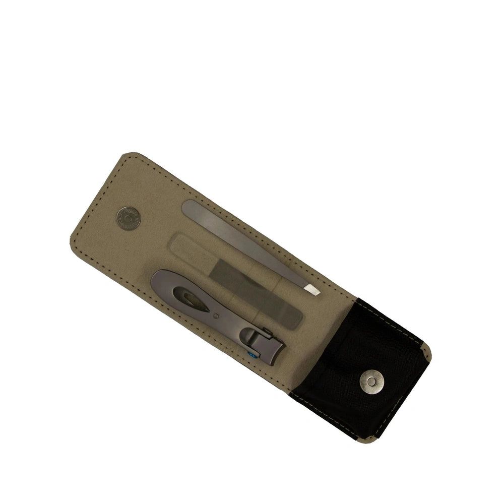 Étui contenant trois outils de manucure : ciseaux, lime et pince à épiler. Étui beige et noir avec fermeture à bouton-pression.