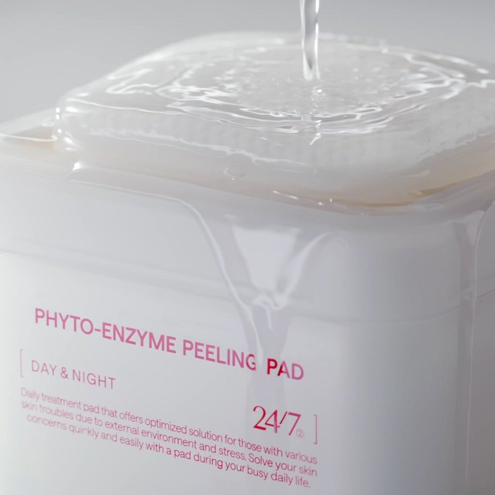 Gros plan sur un contenant blanc avec "PHYTO-ENZYME PEELING PAD". Liquide versé sur les pads.