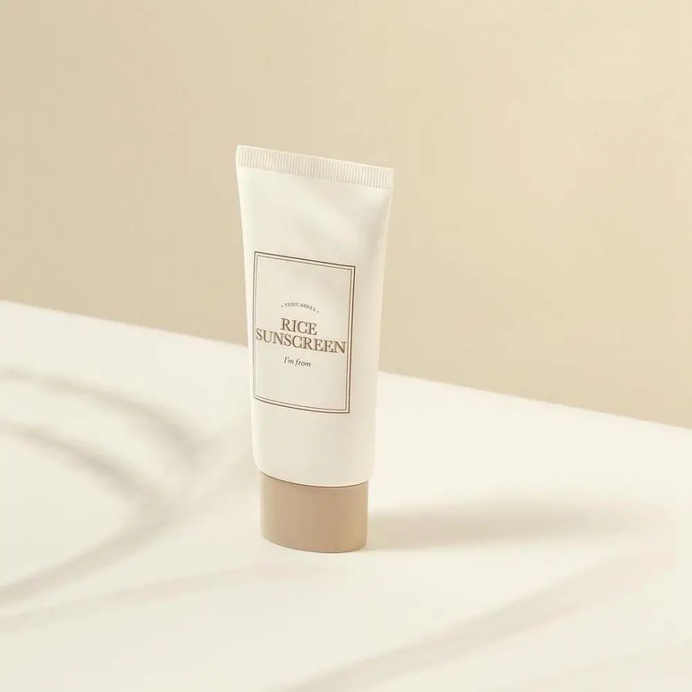 Crèmetube met opschrift 'Rice Sunscreen' en 'I'm from'. Beige dop op witte achtergrond.