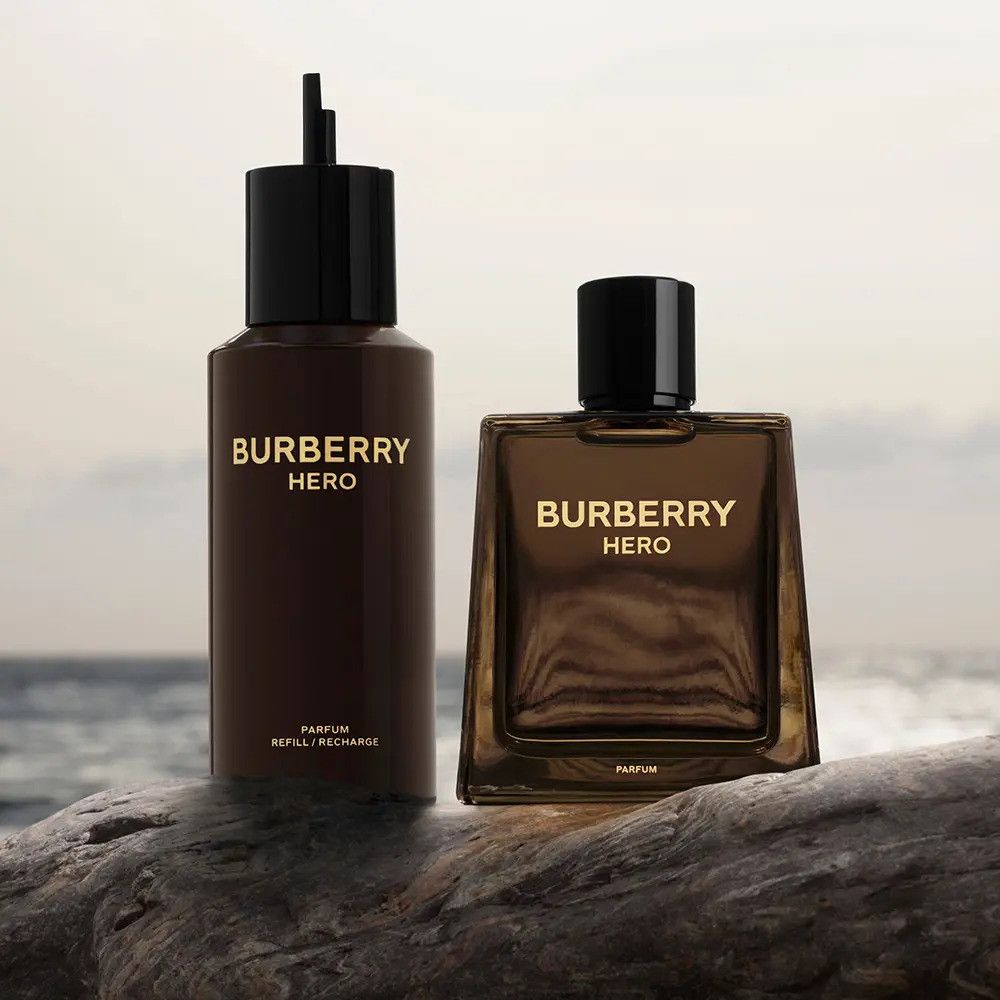 Twee bruine flacons. Eén is langwerpig, de andere vierkant. Beide dragen de gouden tekst BURBERRY HERO.