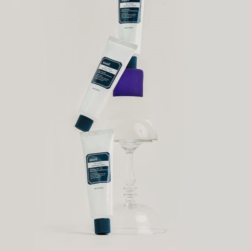 Meerdere tubes met blauwe dop. Opschrift: klairs Rich Moist Soothing Cream. Op glas.