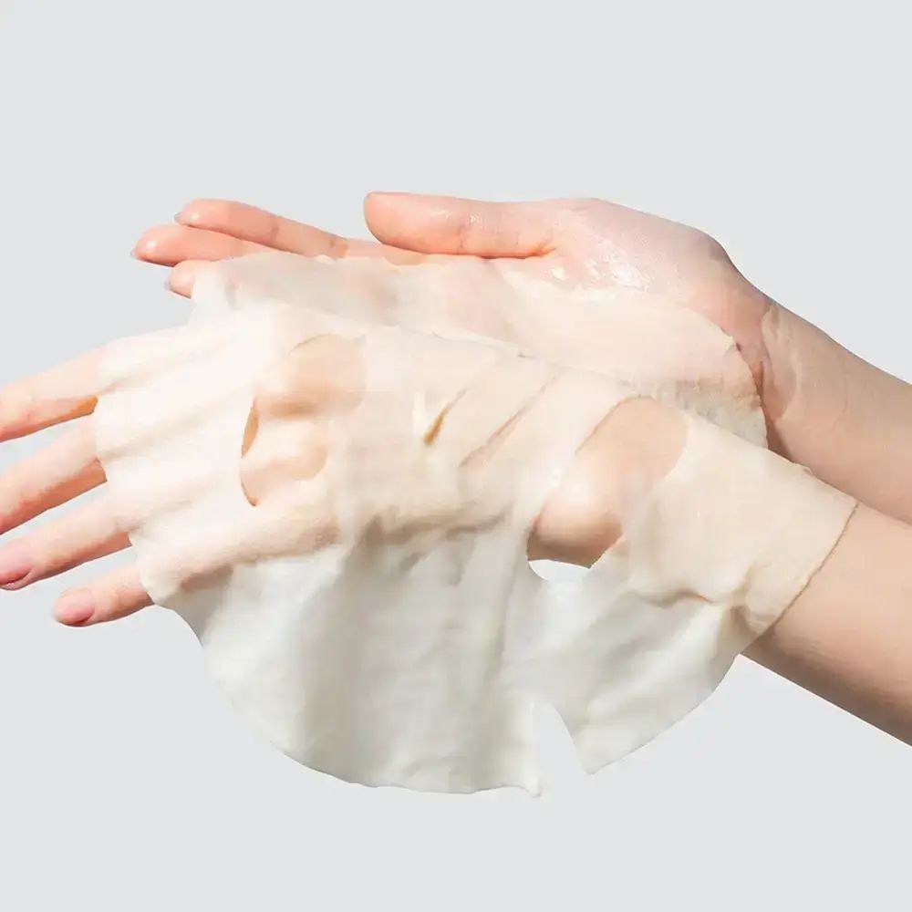 Gezichtsmasker in handen. Masker met openingen voor ogen en mond. Lichte, transparante textuur.