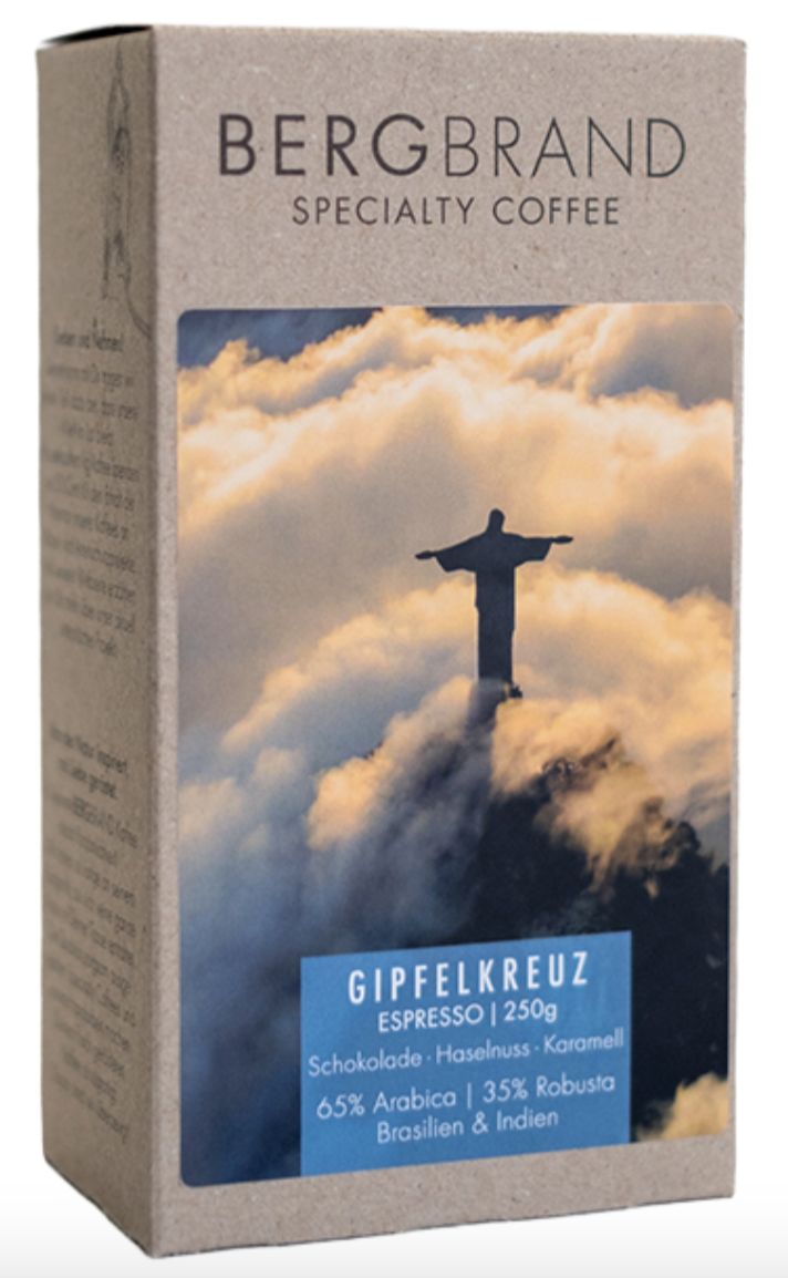 Paquet de café avec le logo BERGBRAND et le texte Gipfelkreuz. Il y a une image sur le paquet.