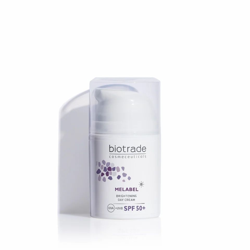 Witte Biotrade Melabel dagcrème. Opschrift: Melabel Brightening Day Cream SPF 50+. Paars logo en tekst. Transparante deksel.
