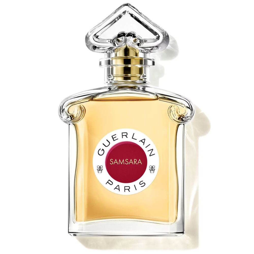 Flacon de parfum avec étiquette rouge. Inscription: Samsara Paris. Flacon transparent avec bouchon doré.
