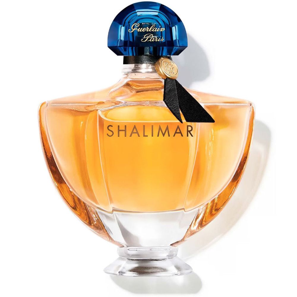 Flacon de parfum avec bouchon bleu, liquide doré et inscription Shalimar. Ruban noir au col.