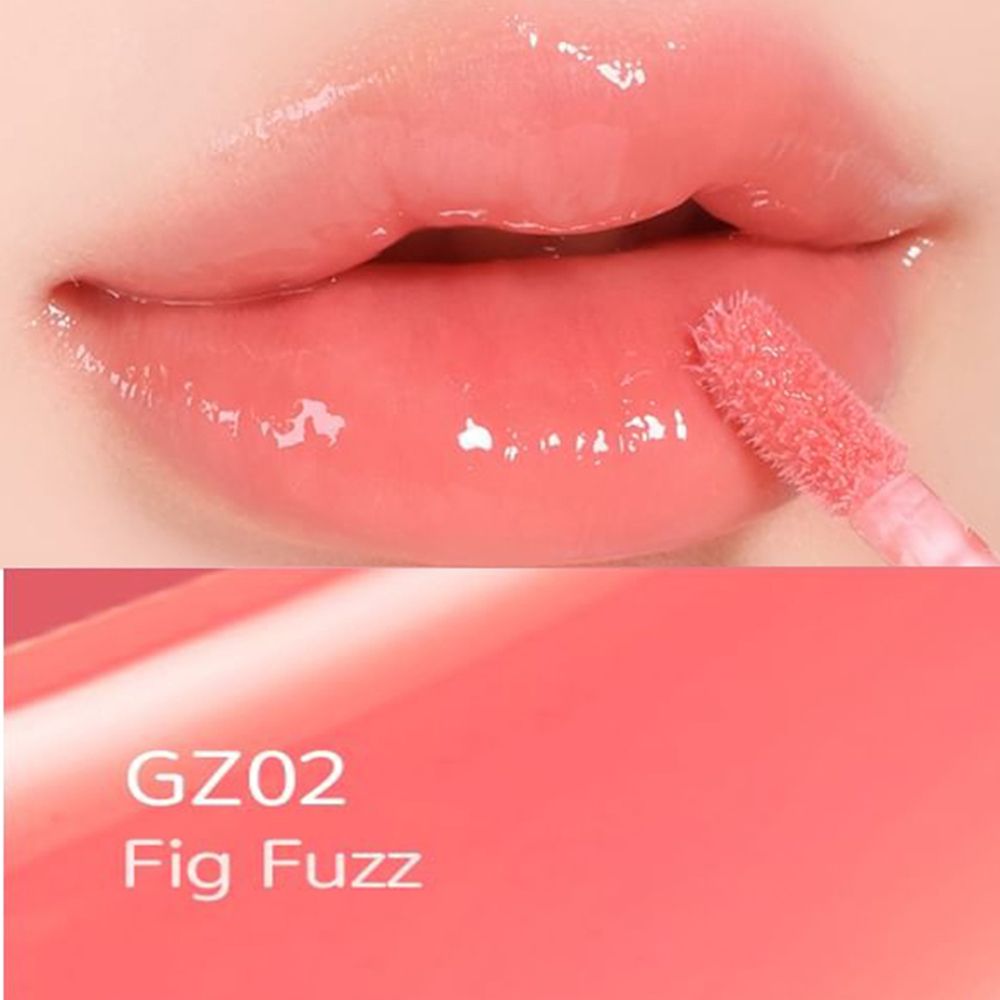 Close-up van lippen met glanzende lipgloss. Applicator zichtbaar. Kleur GZ02 Fig Fuzz.