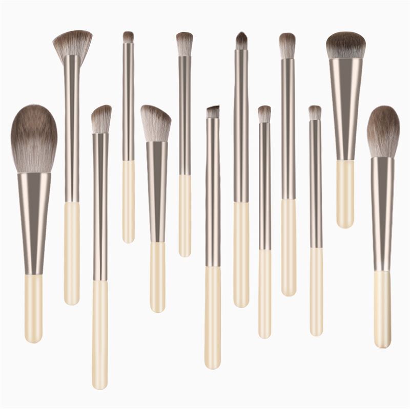 12 pinceaux de maquillage avec manches crème et viroles argentées. Différentes formes de têtes.