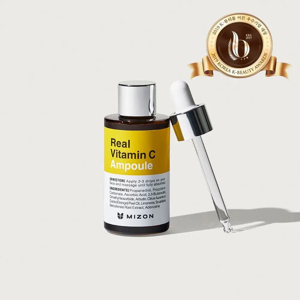 Bruine glazen fles met geel etiket. Opschrift: Real Vitamin C Ampoule. Met pipet en onderscheiding.