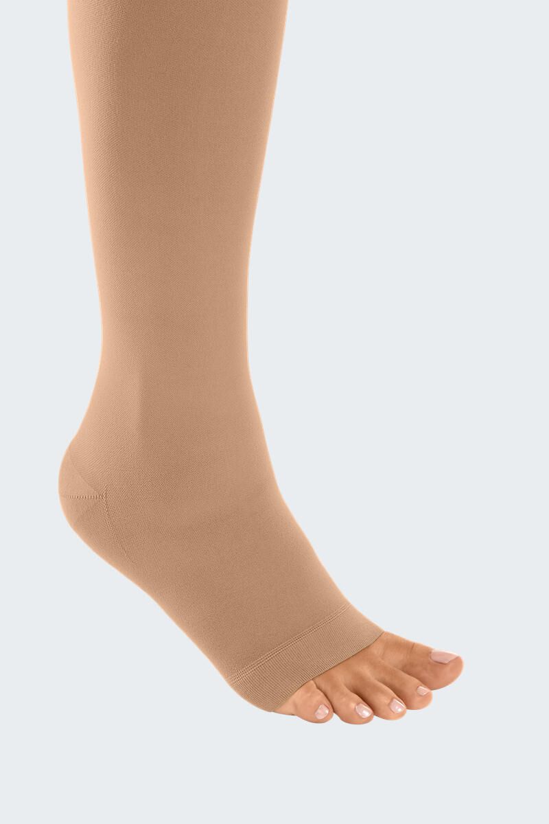 Bas de compression couleur chair, bout ouvert. Matière fine. Gros plan du pied.
