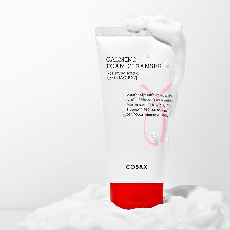 Witte tube met rode dop in schuim. Opschrift: Calming Foam Cleanser, ingrediënten. Merk: COSRX.