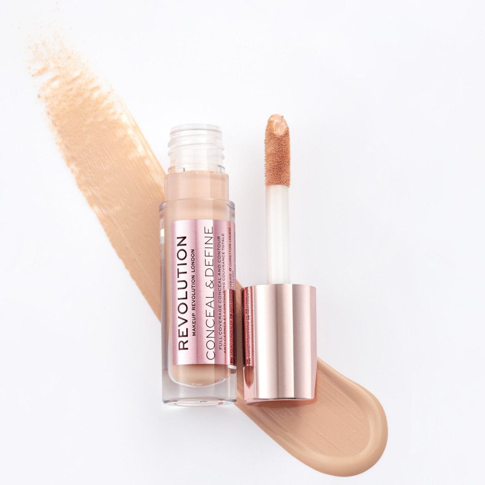 Flacon de correcteur avec applicateur. Bouchon rose doré, flacon transparent. Nom du produit visible.