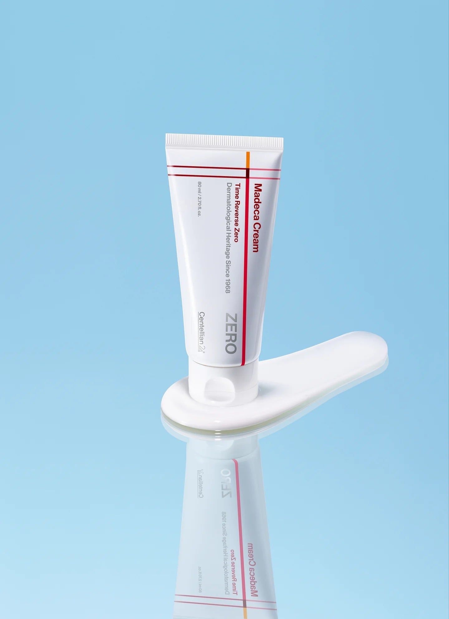 Un tube de crème Madca sur une cuillère blanche, devant un fond bleu.