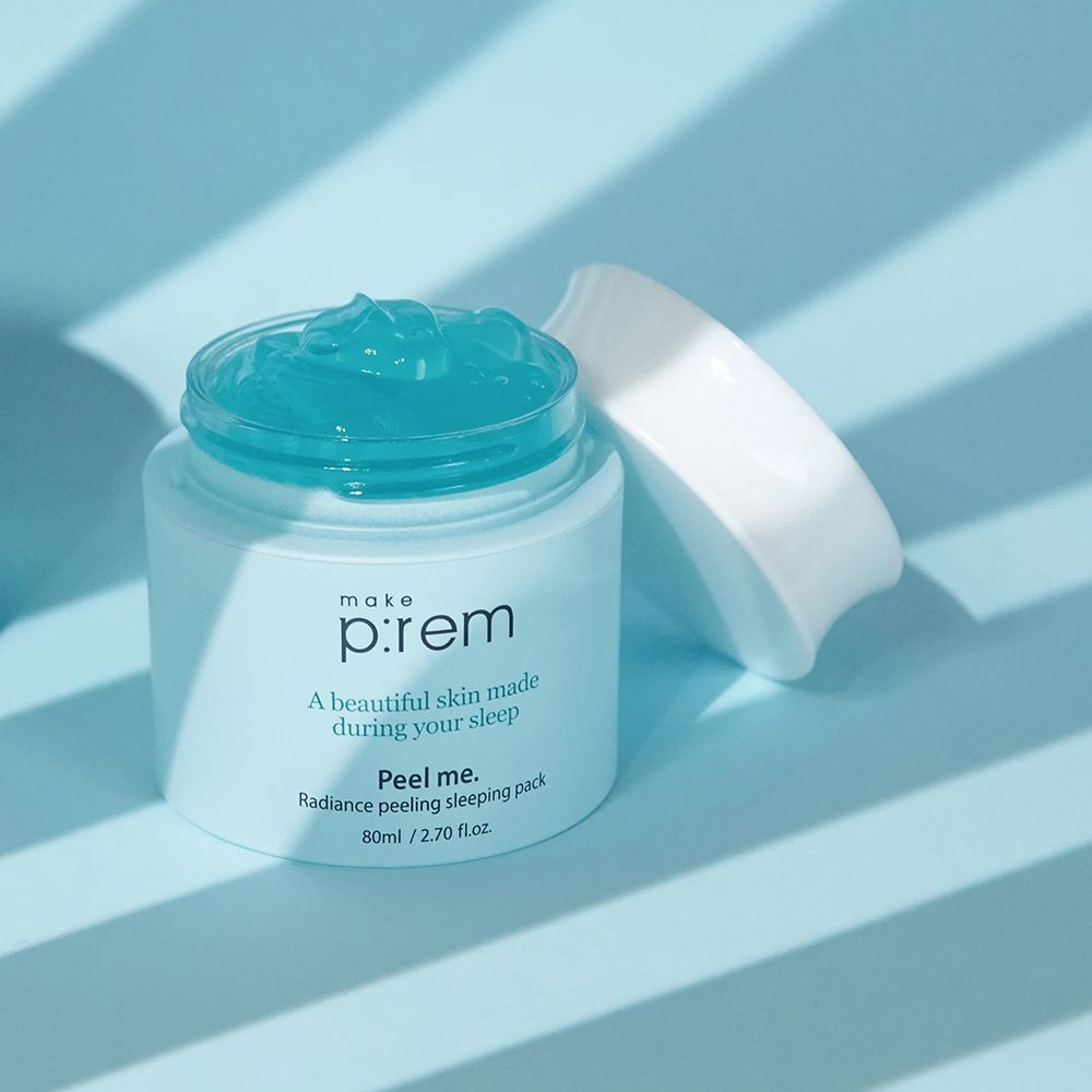 Open lichtblauwe pot met blauwe gel. Opschrift: make p:rem, Peel me. Radiance peeling sleeping pack. Witte deksel ernaast.