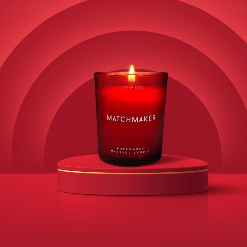 Rode geurkaars 'MATCHMAKER' op een rood podium. Brandend met vlam.