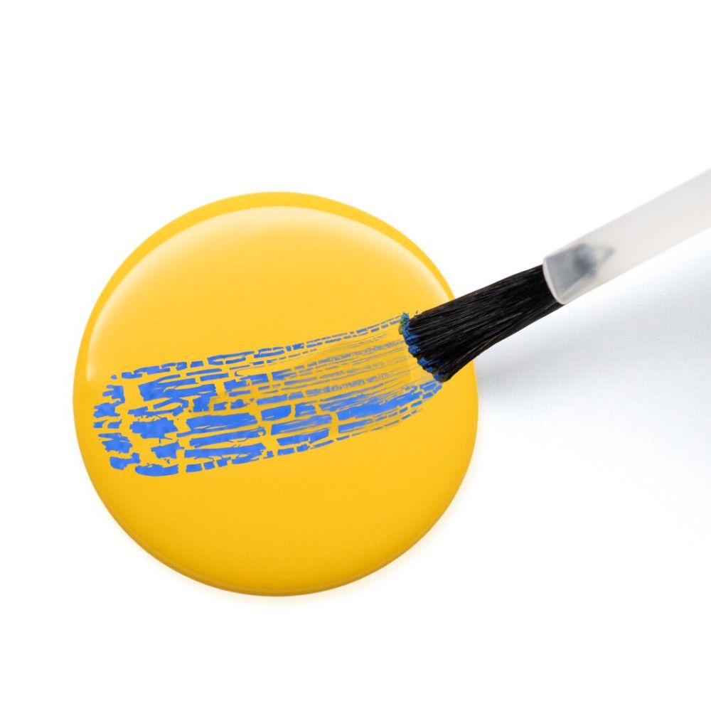Gele nagellak met blauw craquele-effect. Penseel toont het effect.