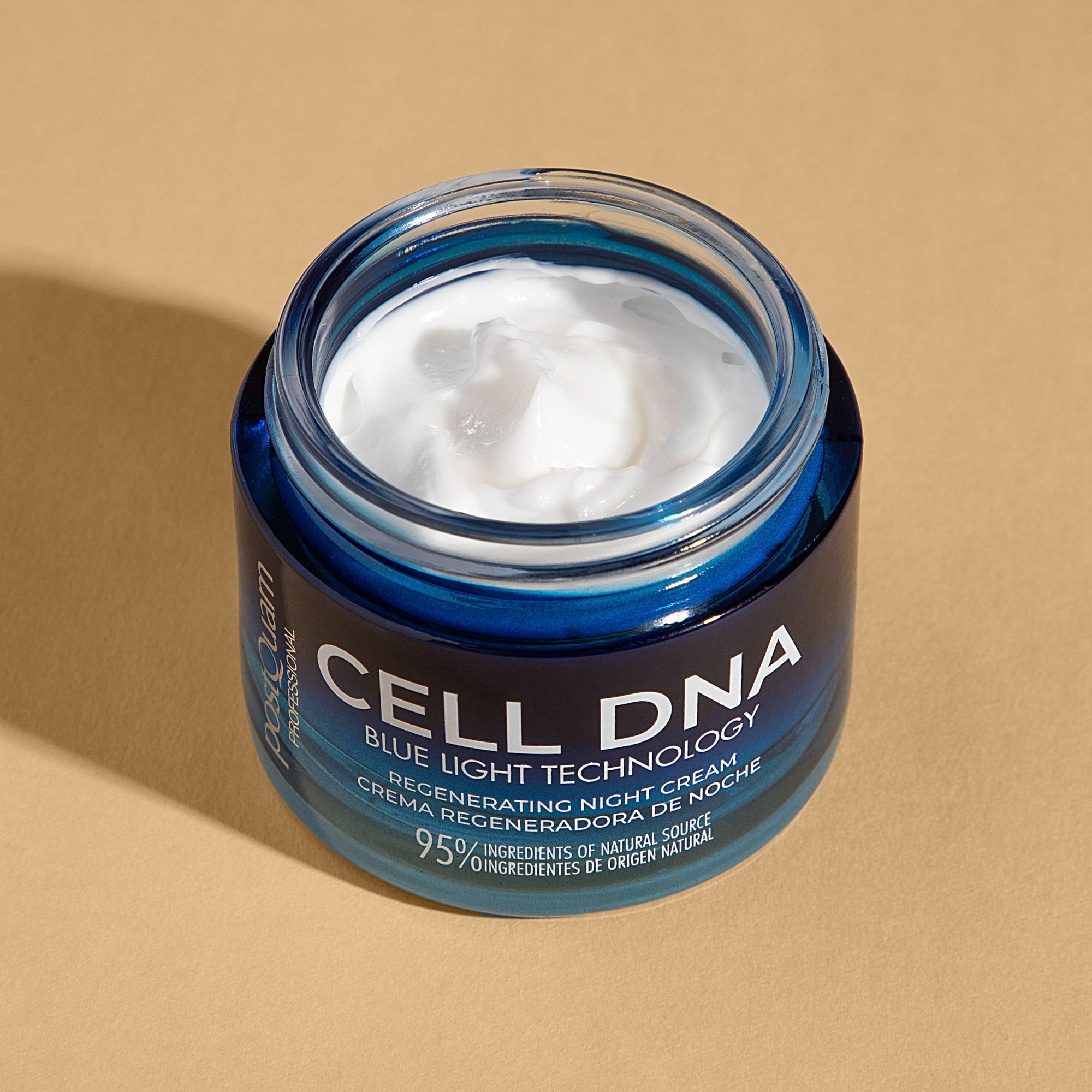 Pot de crème ouvert avec crème blanche. Inscription CELL DNA, Blue Light Technology, Regenerating Night Cream. 95% ingrédients naturels.