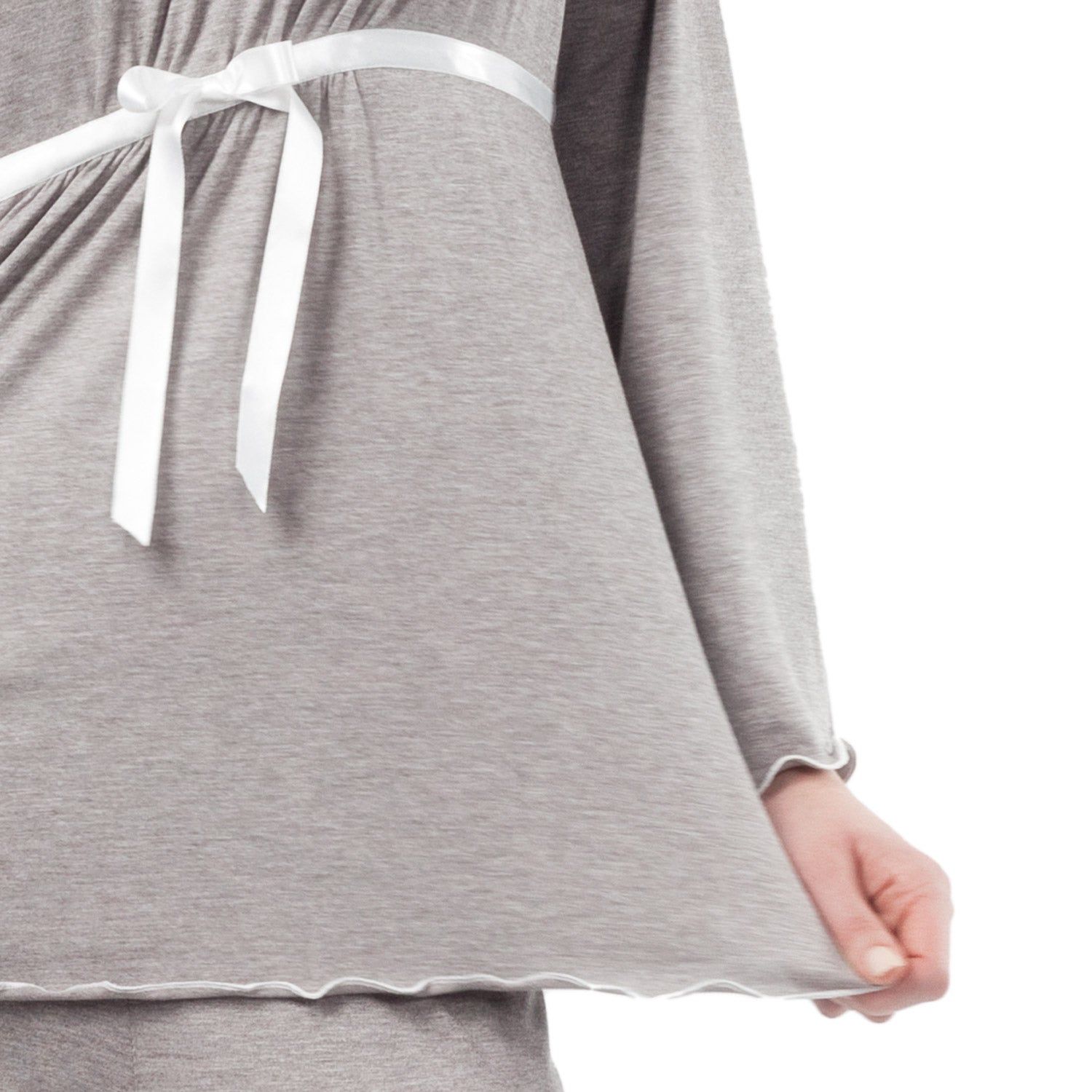 Close-up van een grijze zwangerschapspyjama. De top heeft een witte zoom en een wit lint.