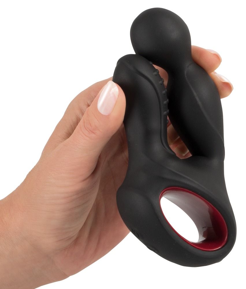 Hand die een zwarte siliconen prostaatstimulator met rode ring en noppen vasthoudt.