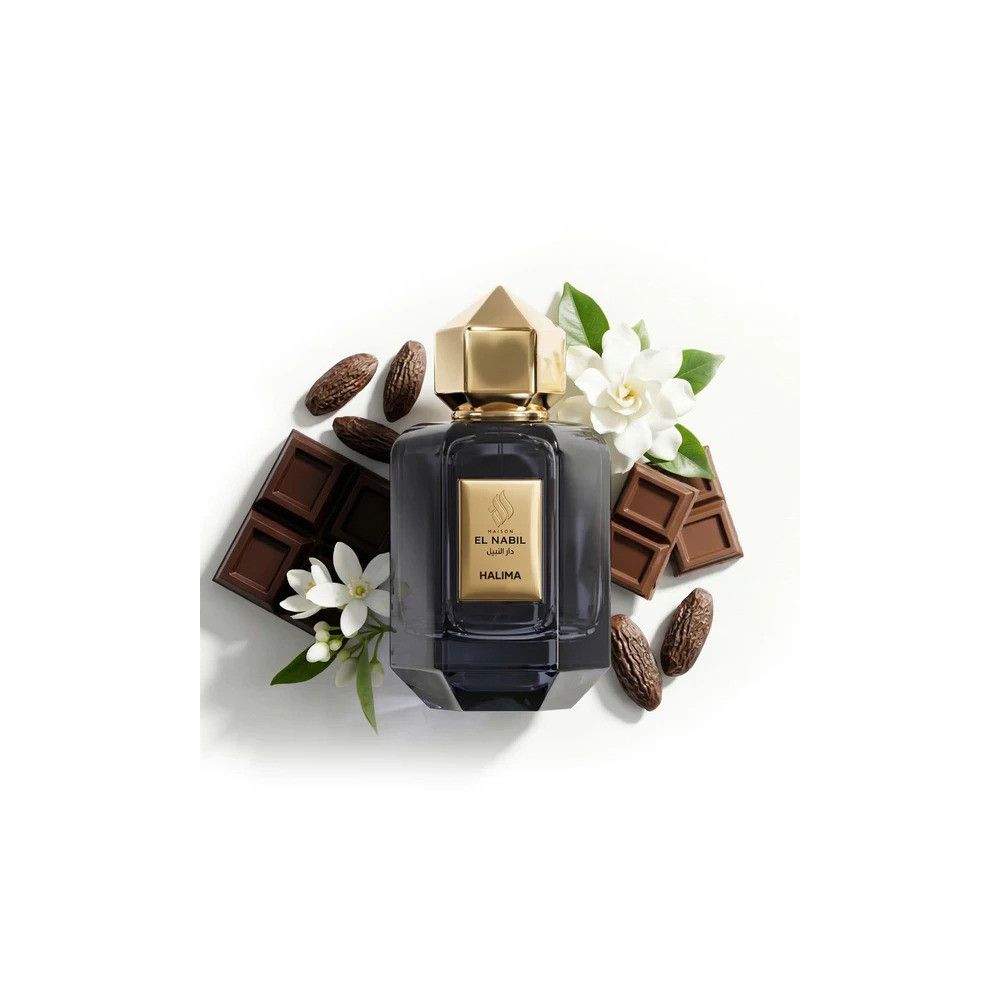Donkergrijs glazen parfumfles met gouden dop, omringd door chocoladestukken, cacaobonen en witte bloemen.
