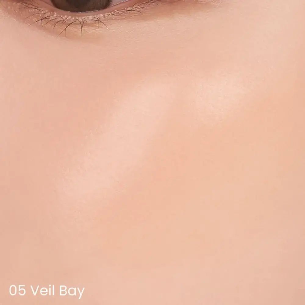 Close-up van een gezicht met aangebrachte roze vloeistof. De tekst "05 Veil Bay" is onderaan te zien.