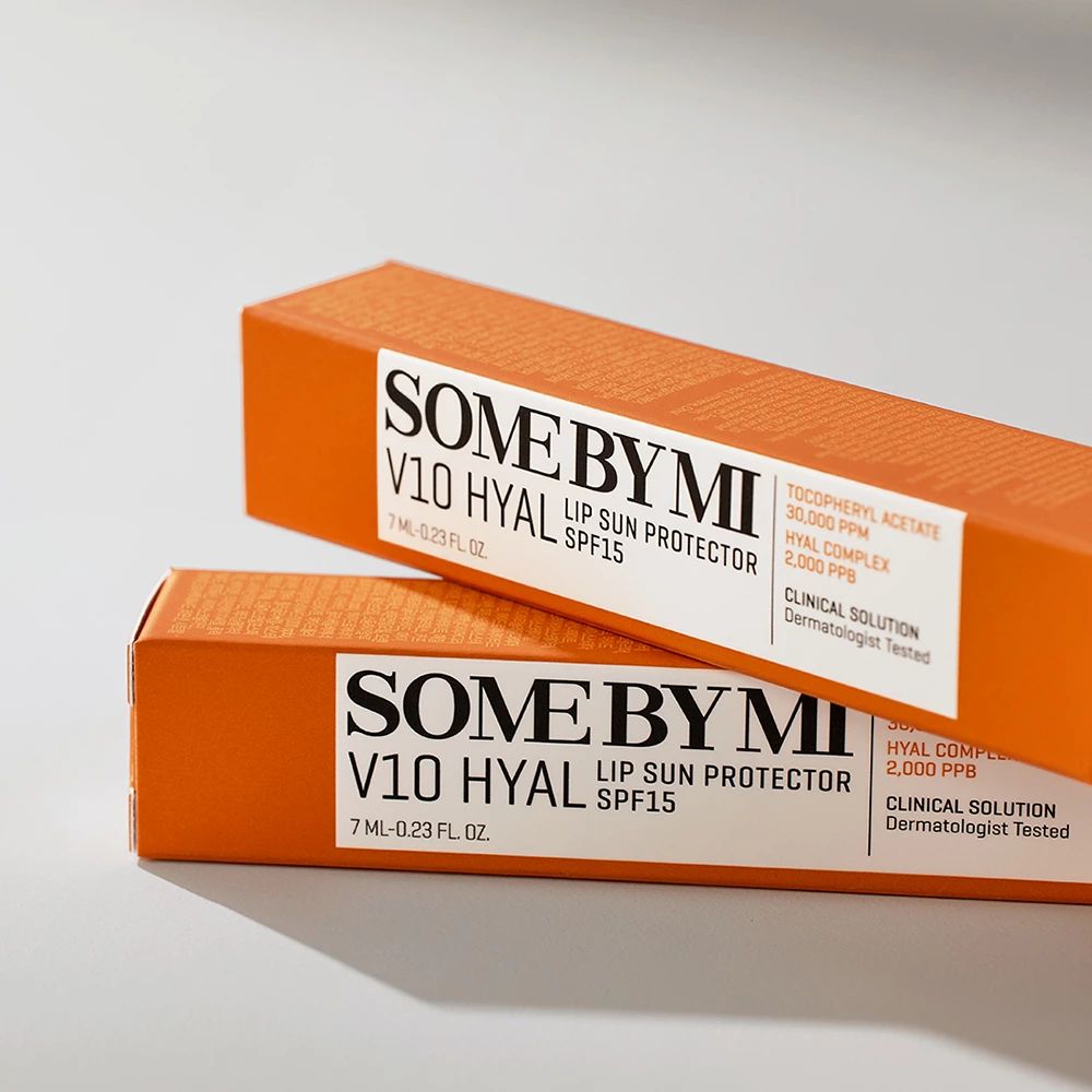 Twee oranje productverpakkingen. Opschrift: SOME BY MI V10 HYAL Lip Sun Protector SPF15.