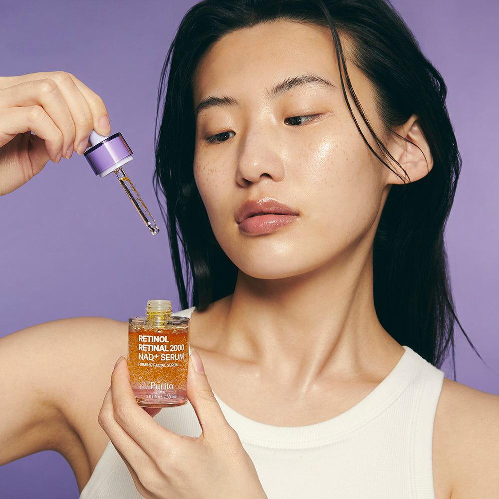 Femme tenant le sérum Purito Retinol Retinal 2000 NAD+ et une pipette.